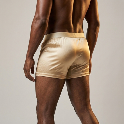 Person wearing beige satin underwear on a neutral background